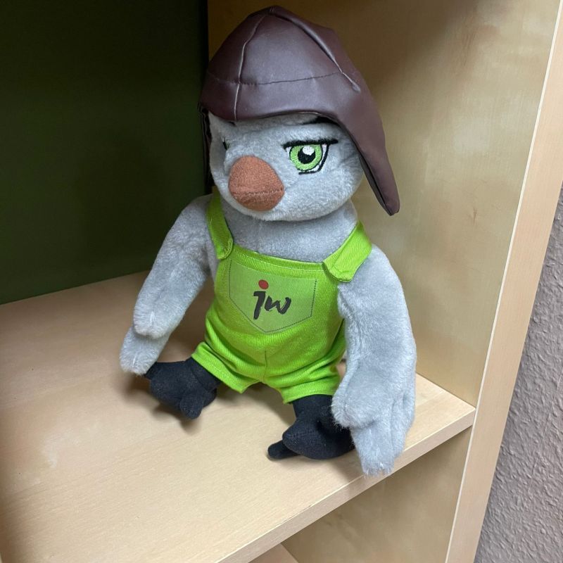 Das Jugendwerksmaskottchen Juwe sitzt im Schrank.