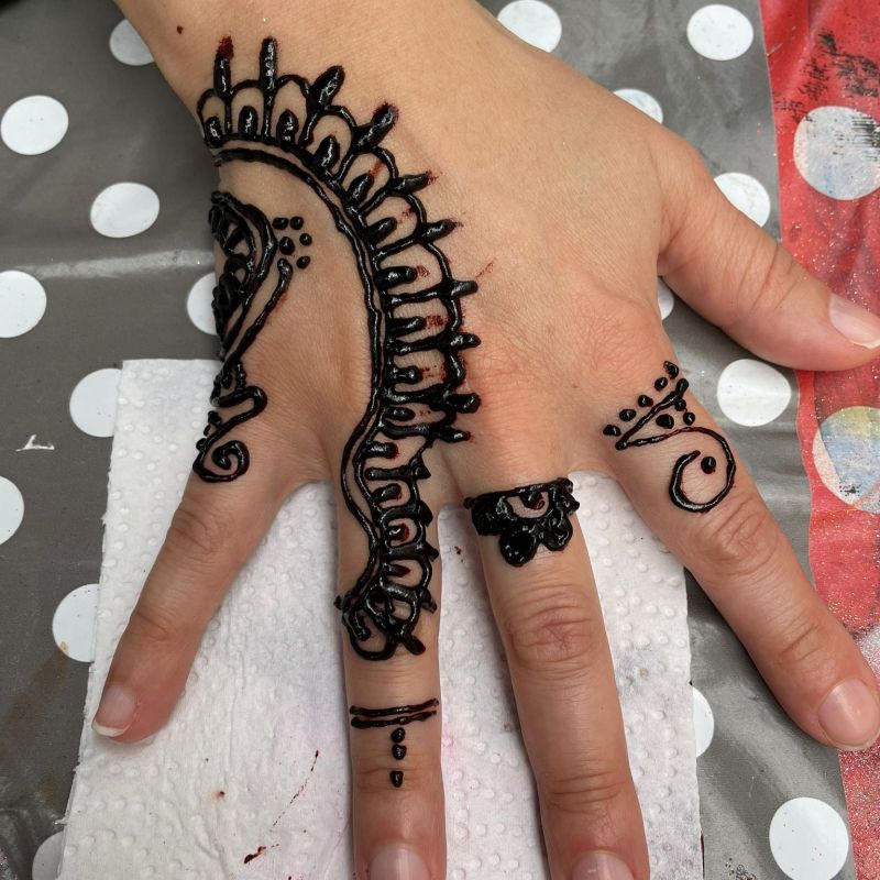 Auf einer Kinderhand ist ein Hennatattoo aufgemalt, was während eines Mobilen Angebots in Kupferdreh entstanden ist.