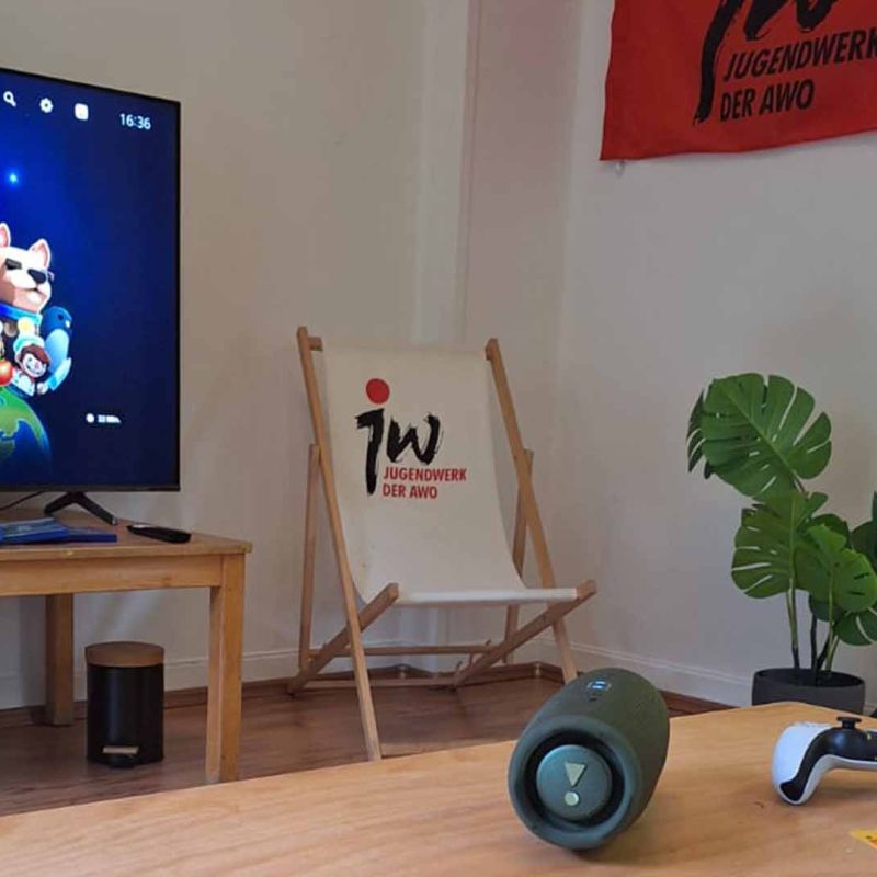 Der neu gestaltete Raum des Jugendclub Werden mit Tischen in der Mitte. Liegestühlen drumherum und Jugendwerksfahne.