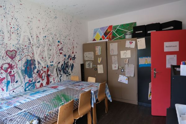 Bastelraum mit Tischen zum Basteln, Stühlen und Schränken mit Bastelmaterial.