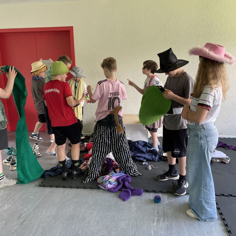 Jugen Menschen können in einem Workshop die Greenscreen Technik ausprobieren. Sie stehen zusammen und verkleiden sich für die Fotos vor der grünen Wand.