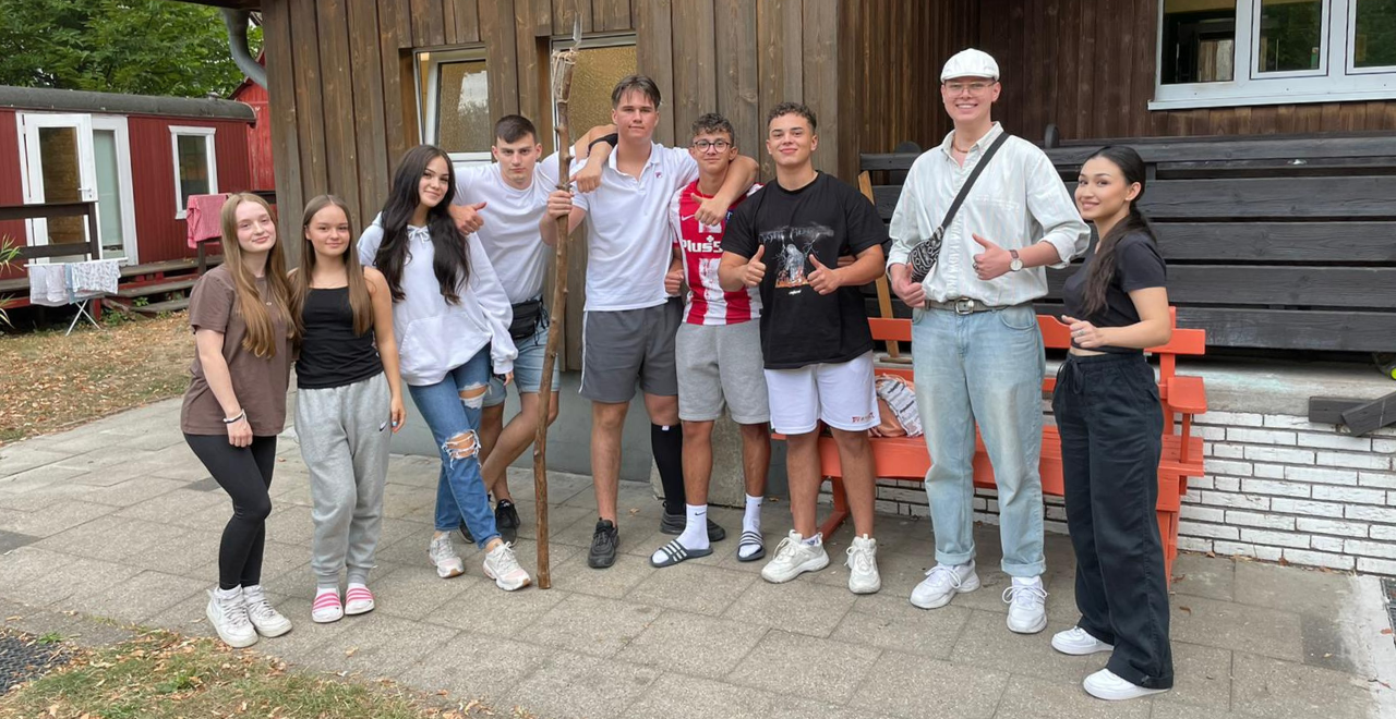 Freund*innen und Besuchende des Jugendclubs H21 Zero stehen draußen zusammen für ein Gruppenfoto.