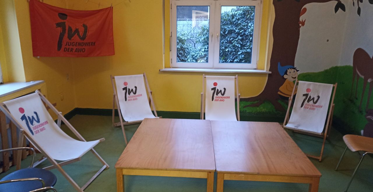 Der neu gestaltete Raum des Jugendclub Werden mit Tischen in der Mitte. Liegestühlen drumherum und Jugendwerksfahne.