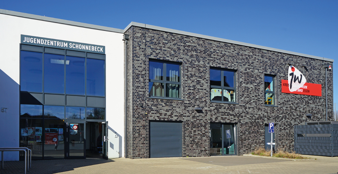 Außenansicht Jugendzentrum Schonnebeck,, mit dunklen Klinkern und weiß verputztem Eingang.