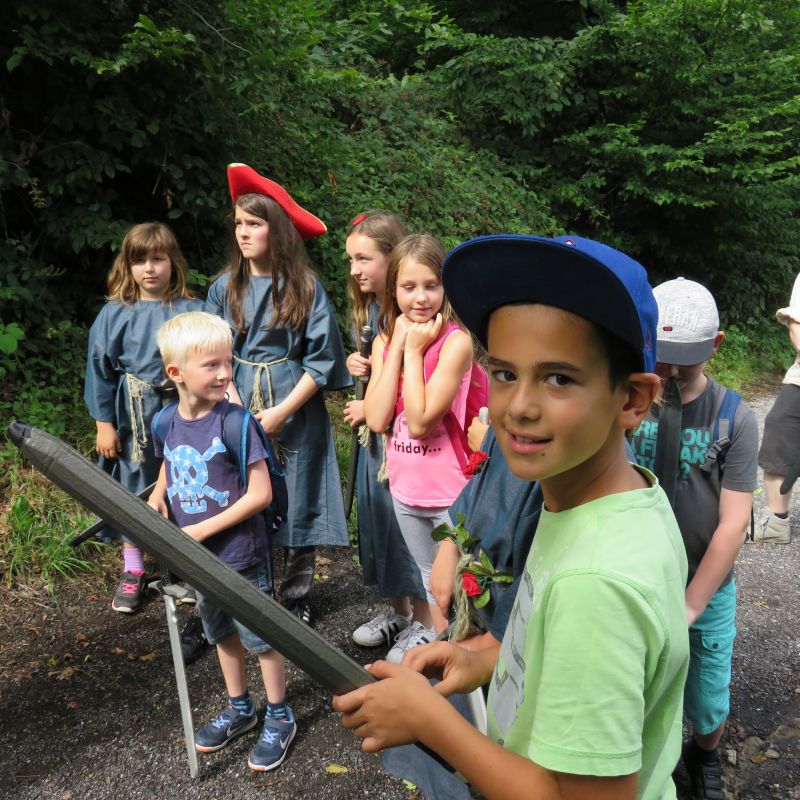 Kinder sind draußen in der Natur auf Schnitzeljagd und mit Utensilien für Piraten verkleidet.