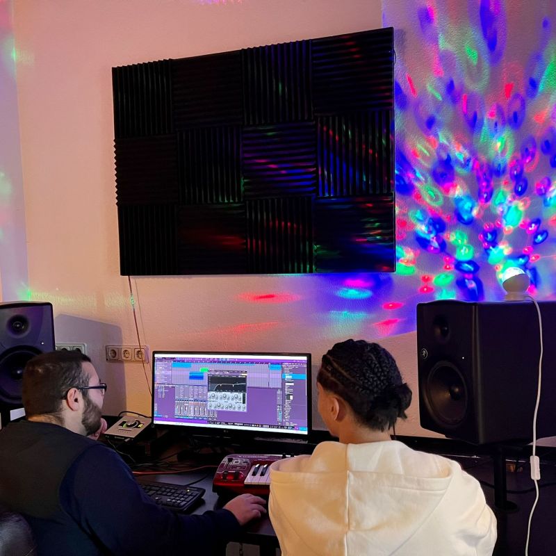Zwei Jugendliche sitzen vor Tontechnik und schneiden selbst gebaute Beats.