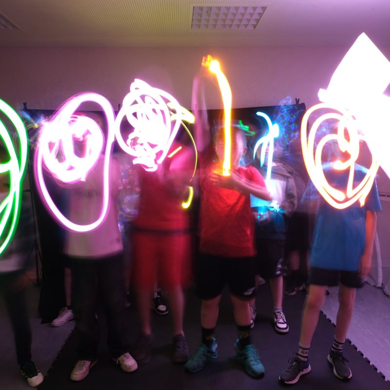 Gruppe aus jungen Leuten probiert Lightpainting aus.