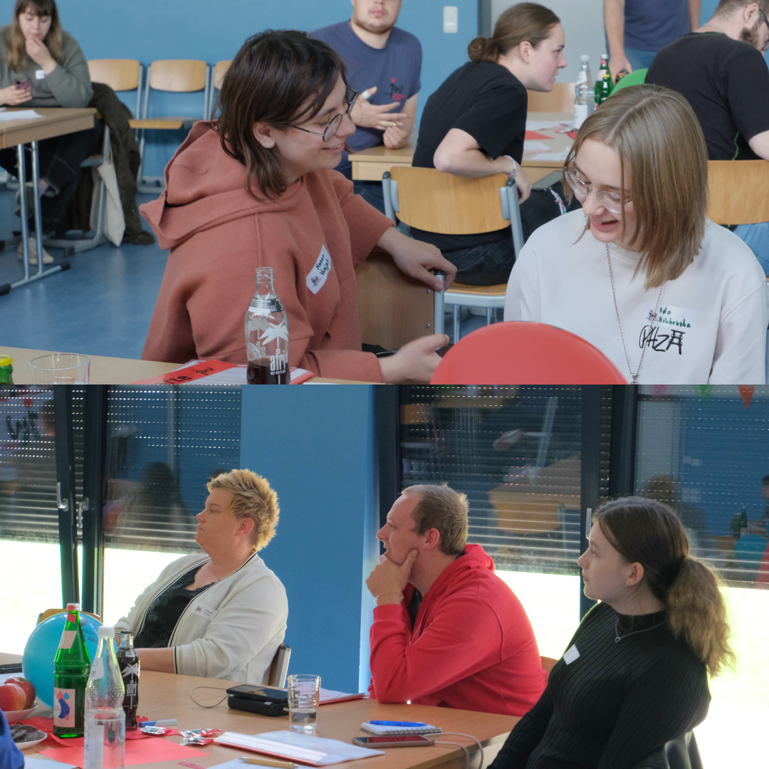 Gäste der Kreiskonferenz sitzen an einem Tisch und hören den Redner:innen zu.