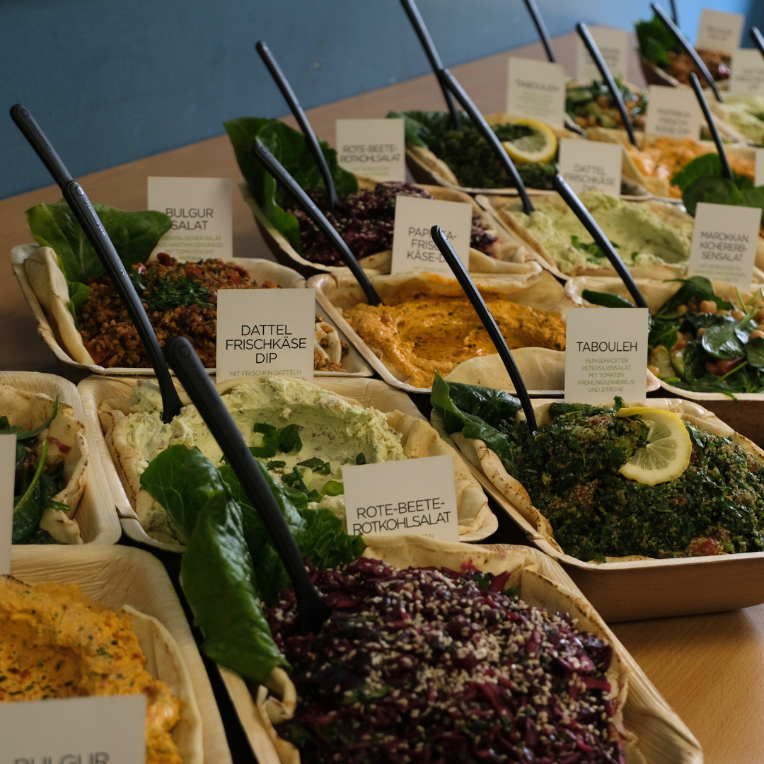 Eine Nahaufnahme zeigt das Buffet mit verschiedenen Dips und Salaten.