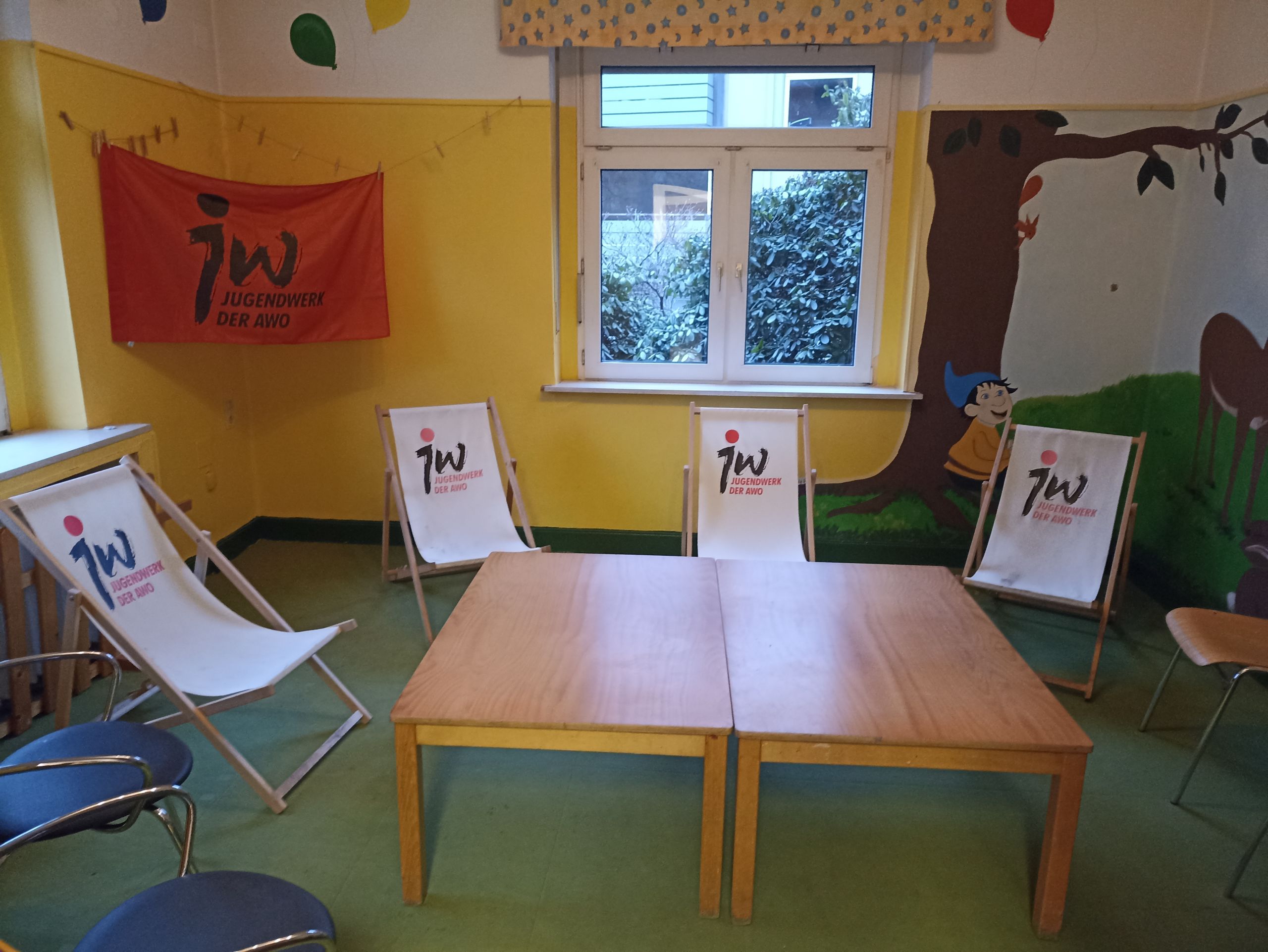 Der neu gestaltete Raum des Jugendclub Werden mit Tischen in der Mitte. Liegestühlen drumherum und Jugendwerksfahne.